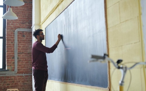 Teacher writing on chalk board